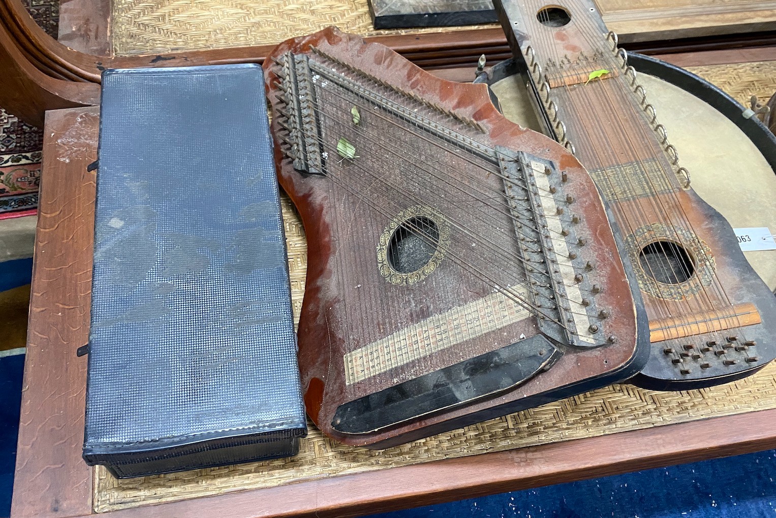 A group of assorted musical instruments comprising two large tambourines, two zithers and a Zenith trumpet